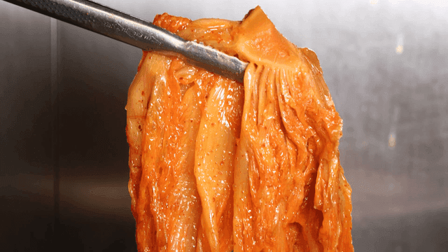 Kimchi stew scooped up with tongs