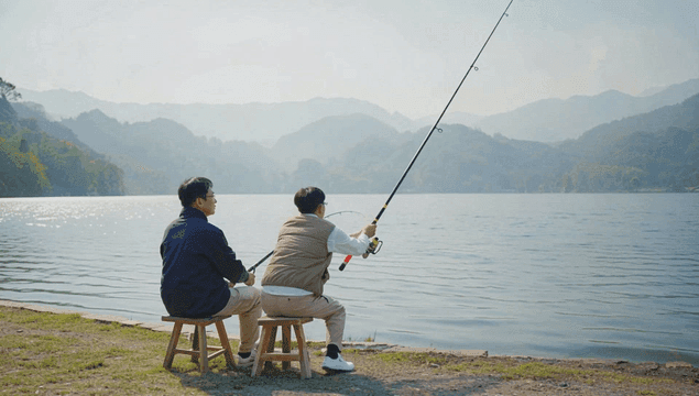 Two friends fishing by a serene lake