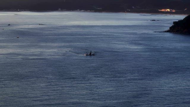 Small boat on a calm sea at dusk