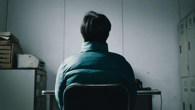 Back of man sitting alone in quiet room