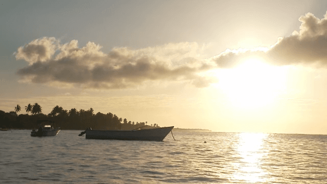 일몰 시 고요한 바다의 보트