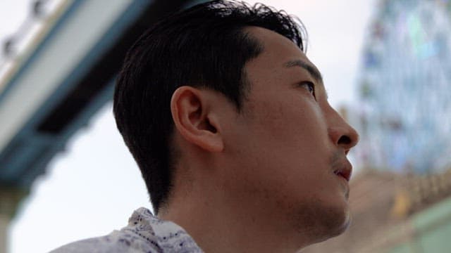 주변을 둘러보며 물을 마시는 남자