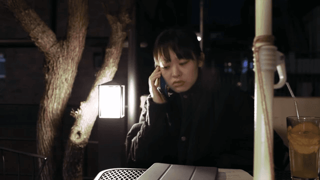 밤에 야외에서 통화를 하는 여성