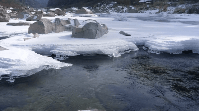 Frozen river with snow-covered rocks