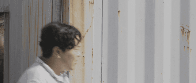 컨테이너 사이를 나와 커플을 바라보는 남자