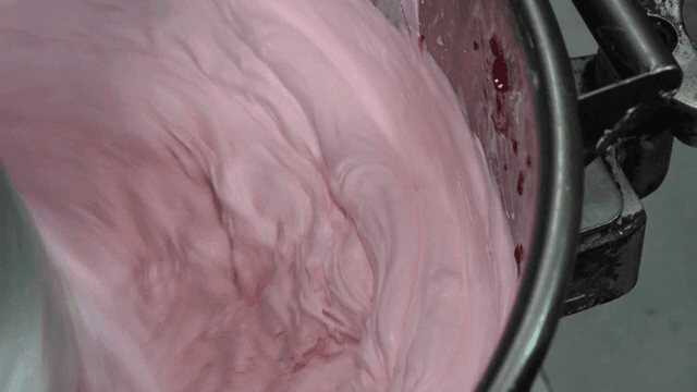 Pink cream being mixed in a bowl