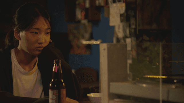 레코드판 술집에서 맥주병과 생각에 잠긴 여성