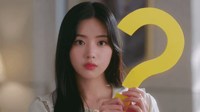 큰 물음표를 들고 있는 젊은 여성