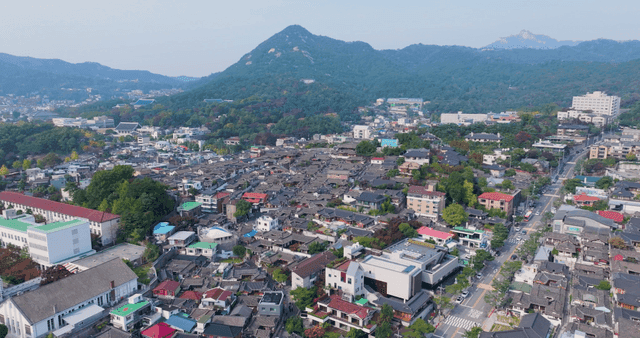 Traditional hanok village with distant mountain view