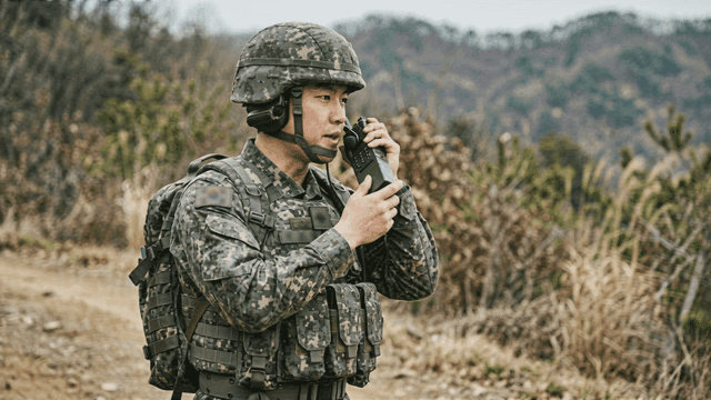 Soldiers communicating via radio in forest