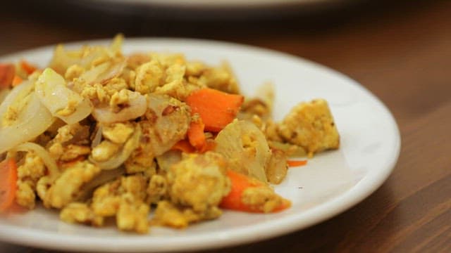 테이블의 흰 접시 위에 차려진 베이컨 말이와 달걀볶음