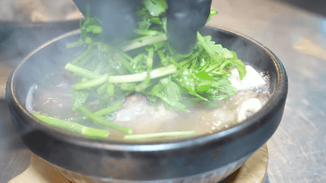 Water celery generously topping earthenware pot galbitang