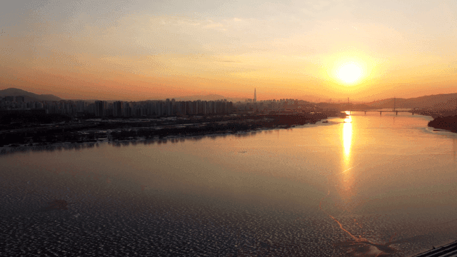 Sunset over a river with city skyline