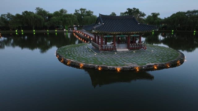 저녁의 고요한 연못 위의 전통 정자