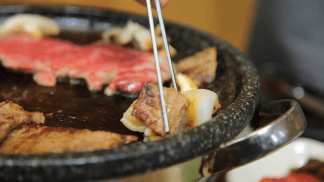 깻잎장아찌에 소고기와 관자를 싸먹는 모습