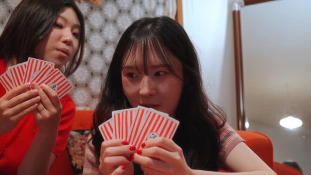 Two friends playing cards indoors