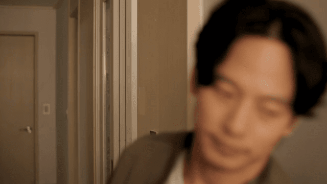 복도를 통해 집으로 들어오는 남자