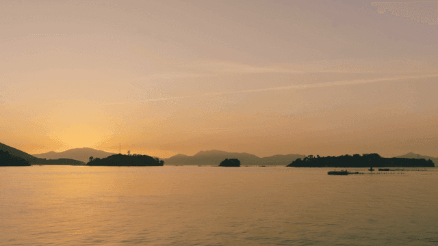 Calm sea sunset with distant islands visible