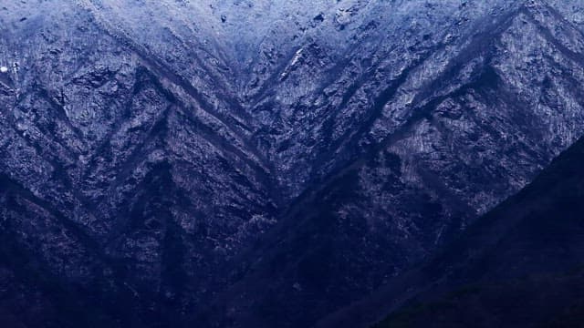 흐린 하늘 아래 광활하게 펼쳐진 눈 덮인 산