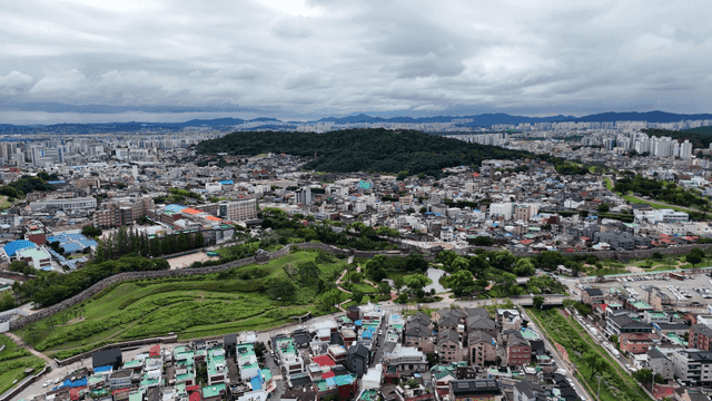 녹색 언덕이 있는 광활한 도시에 역사적인 성곽