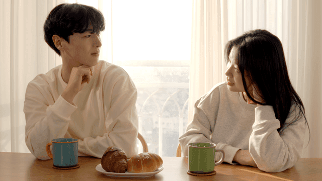 빵과 커피가 있는 식탁에서 대화하는 커플