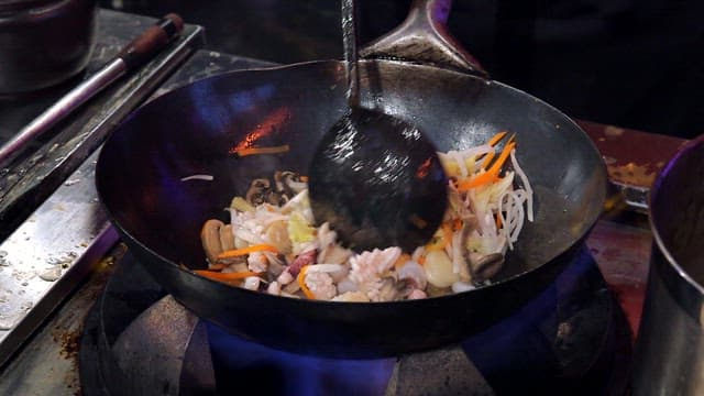 Stir-frying in a flaming wok at high heat