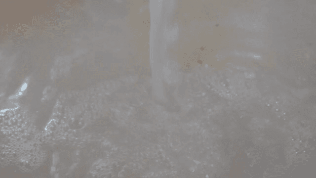 White liquid being poured into a pot