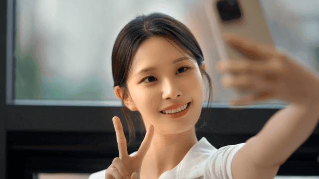 창가에서 셀카를 찍는 젊은 여성