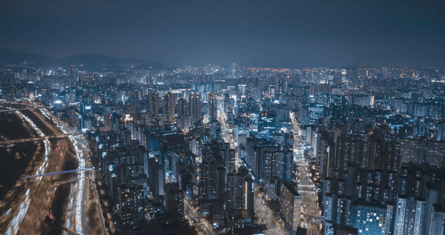 Bustling city scene with cars speeding by at night