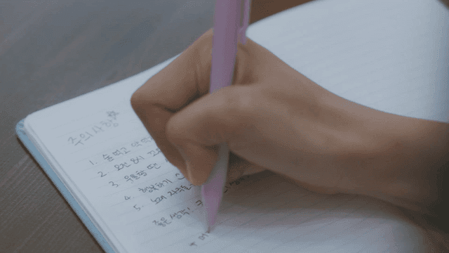 노트에 메모를 적는 사람