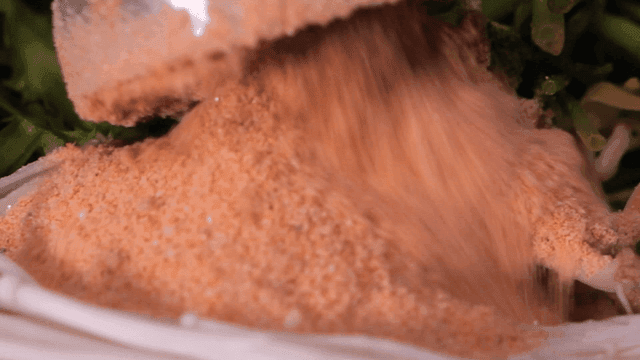 Seasoning being poured over vegetables