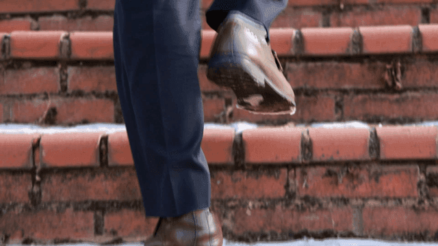 Shoes of person climbing brick stairs
