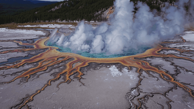 Colorful geothermal spring with steam rising