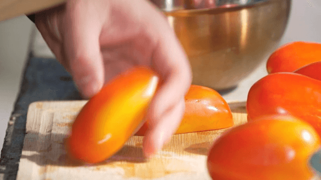 도마 위에서 신선한 토마토 자르기