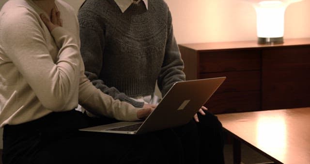 Two People Collaborating on a Laptop Indoors