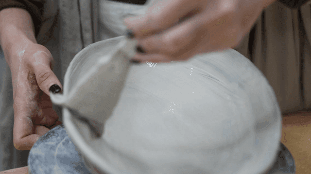 A person painting a ceramic bowl
