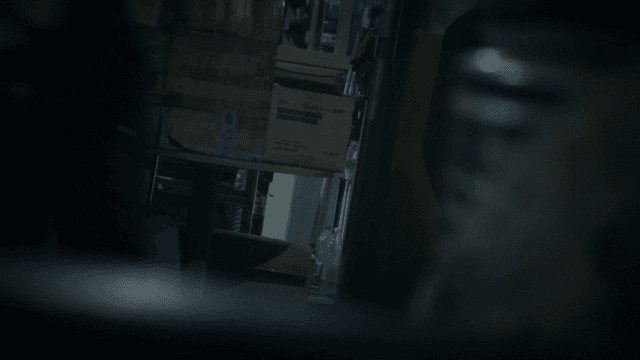 People moving boxes in dark room