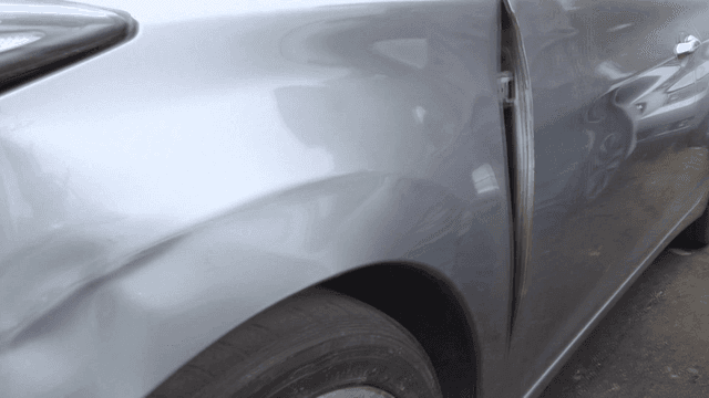 눈에 띄는 찌그러짐이 있는 손상된 차