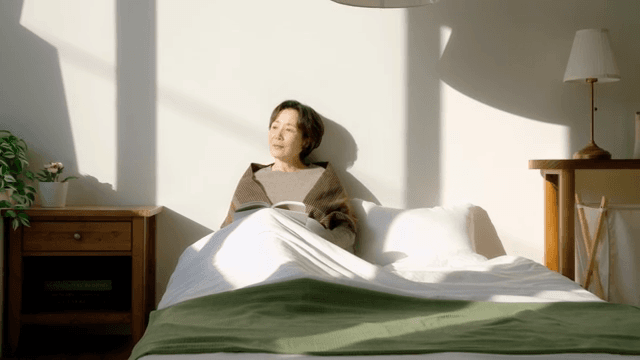 햇빛 속에서 침대에 앉아 책을 읽는 여성