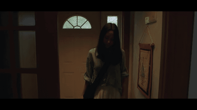 Woman entering a dimly lit house