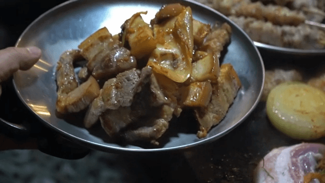 접시에 담긴 김치와 삼겹살 구이