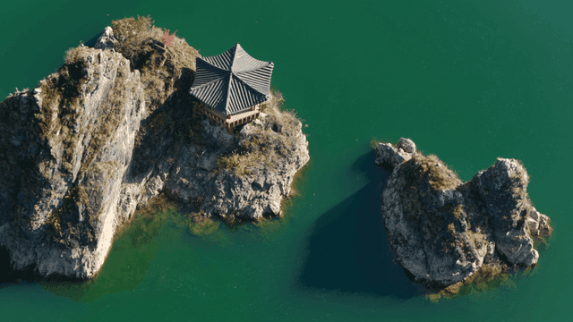 바위로 형성된 섬 위의 고풍스러운 정자