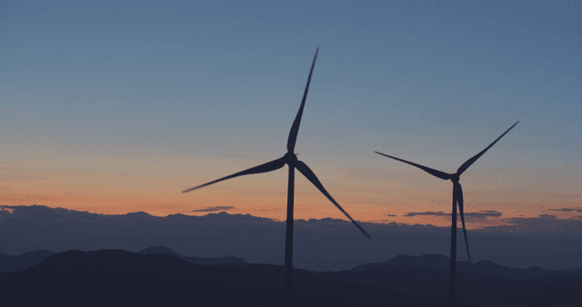 산속 일몰의 천천히 돌아가는 풍력 터빈