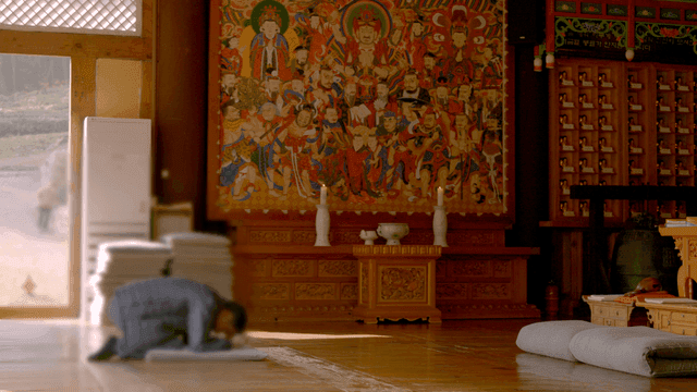 Person bowing in temple hall