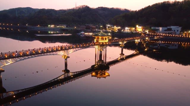 밤에 고요한 강 위의 조명 다리