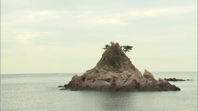 Isolated Rocky Island in Calm Sea