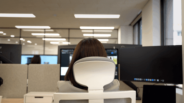 Back view of female office worker concentrating on computer screen
