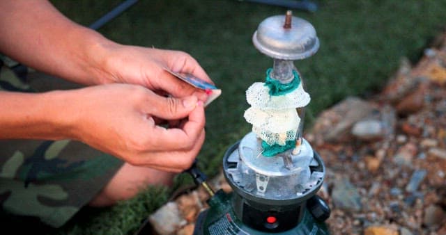 Man Igniting a Portable Gas Stove Outdoors