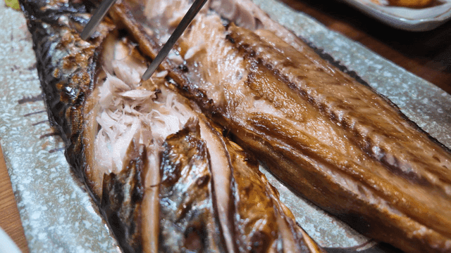 Chopsticks for picking up grilled mackerel served with salad