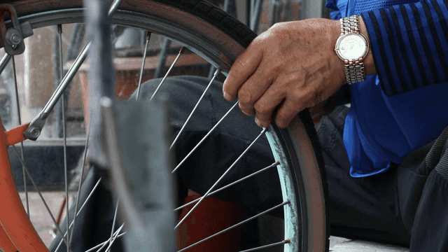 Person repairing a bicycle wheel